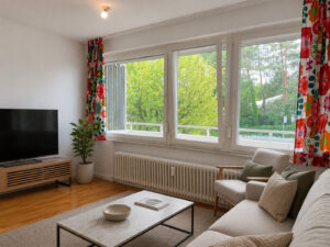 Wohnzimmer mit Fensterfront zum Balkon (virtuell aufbereitete Darstellung)